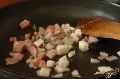 Грудинку мелко нарезать, вместе с веточкой тимьяна обжарить на сковородке, чтобы жир немного вытопился.