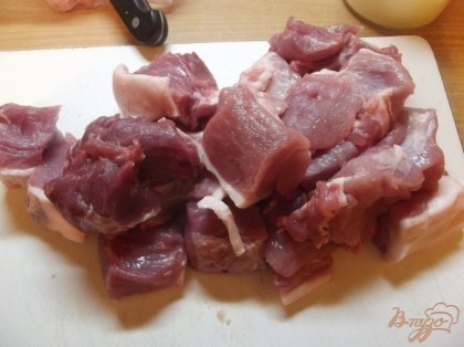 Нарежьте свинину кусочками размером с детский кулачок.