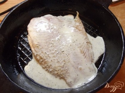 Выпекать рыбу лучше в небольшой чугунной сковородке. Смажьте ее обильно растительным маслом и положите рыбу. Соус, оставшийся в миске, влейте сверху рыбы в сковородку.
