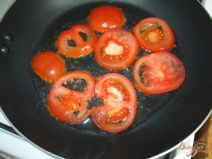 Порезать кружками помидоры и слегка обжарить на растительном масле.