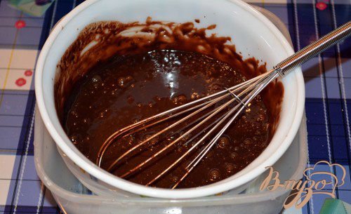 На водяной бане растопите шоколад полностью. Для этого возьмите две емкости. Например кастрюлю и миску. В кастрюлю до половины налейте воды. Миску поставьте сверху на кастрюлю. Вскипятите воду в кастрюле. Вода в свою очередь нагреет миску и растопит шоколад. Следует постоянно помешивать шоколад. Как только шоколад растаял, влейте в него 100 мл сливок и размешайте. Снимите миску с кастрюли. В другую емкость налейте холодную воду. Поставьте в нее миску.