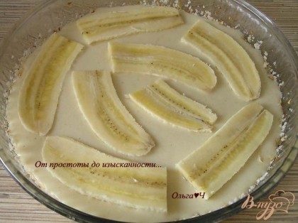 Вылить тесто в смазанную маслом и посыпанную панировочными сухарями форму для выпечки. Сверху разложить бананы, разрезанные вдоль и поперек на 4 части. Смазать бананы мятным сиропом.