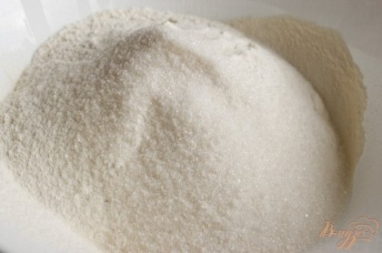 Муку просеять в большую миску, добавить большую щепотку соли, разрыхлитель, соду, ванильный сахар и 60 г сахара. Перемешать.
