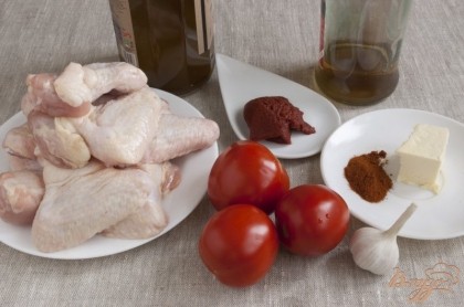 Подготовить куриные крылышки, масло оливковое и масло сливочное, томатную пасту, винный уксус, помидоры, чеснок, паприку.