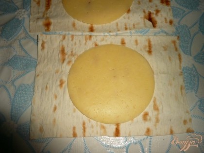 Затем на каждый кусок лаваша кладем сыр. Если сыр в нарезке, то просто по тонкому кусочку, если же единым кусочком, то сыр натираем на терке.
