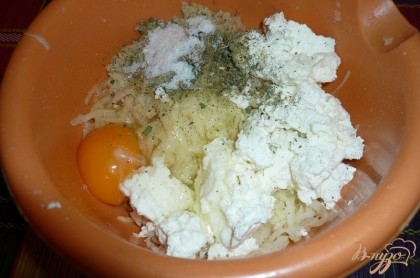 После этого к натертому картофелю добавляем куриное яйцо (если мелкие, то пару яиц), творог (любой, какой есть в наличии - жирность не важна), соль и любые специи или сушеные травы по вкусу. Если есть возможность, хорошо добавить свежую зелень (зеленый лук, укроп - по вашему вкусу), предварительно её измельчив.