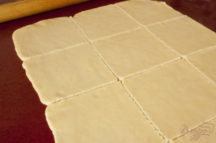 Тесто раскатать в тонкий пласт прямоугольной формы. Нарезать тесто на квадраты примерно 10-12 см по стороне.