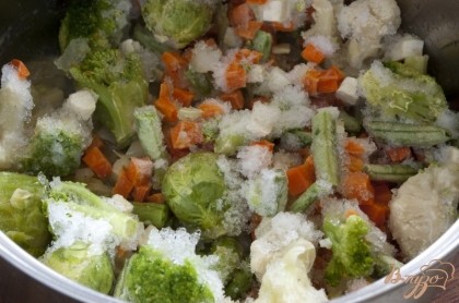 Замороженную смесь овощей желательно разморозить. Пусть постоит при комнатной температуре, лишнюю влагу лучше слить. Затем овощи, включая очищенную и мелконарезанную репчатую луковицу, немного обжарить на сливочном масле.