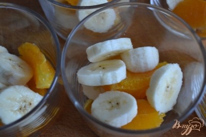 По стаканчикам разложить кусочки апльсина и банана.