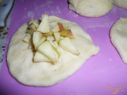 Шарик теста разминаем в лепешку, в центр выкладываем яблочную начинку.