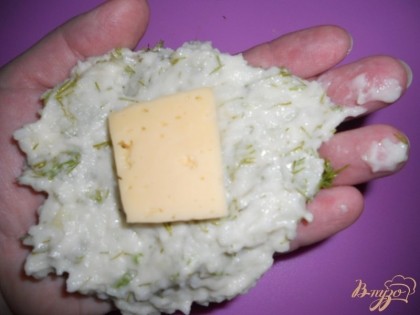 В центр получившейся картофельной лепешки кладем кусочек сыра или же другую начинку по вкусу. Далее также мокрыми руками залепляем лепешку так, чтобы начинка была полностью скрыта.