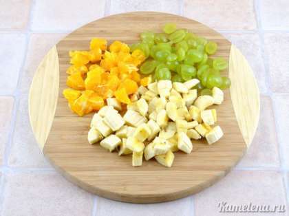 Подготовить фрукты. Банан порезать кубиками, ягоды винограда порезать пополам, апельсин очистить от кожуры и порезать кубиками.