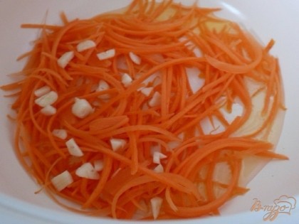 Морковь чистим, тонко нарезаем или натираем на крупной терке. В чащу мультиварки наливаем растительное масло, выкладываем морковь и чеснок (очищенный, каждых зубчик разрезаем на несколько частей). Обжариваем в режиме "жарка" минут пять.