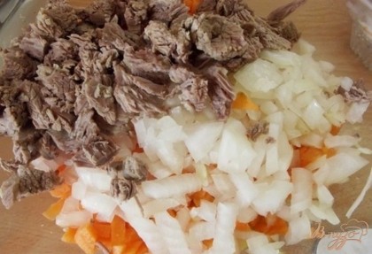 Сгрузите в миску мясо. Лук и морковь хорошенько вымойте и очистите от кожуры. Нарежьте их не крупными кубиками, чуть крупнее чем в салат. Ссыпьте овощи к мясу. Кабачки хорошенько вымойте и нарежьте такими же кубиками, как и остальные овощи. Если у вас есть возможность, приобретите синенькие и добавьте их в место половины кабачков. Только предварительно вымочите их в соли в холодной воде примерно пол часа.