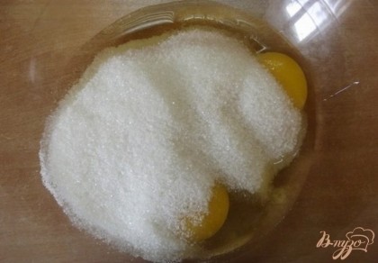 Сахар через сито просейте поверх яиц. Просеивание сахара, даже если на первый взгляд он не имеет комочков, необходимо. Это сделает тесто более однородным.