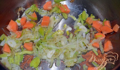 К проготовленному луку-порею добавьте морковь.