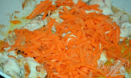 Переверните мясо на другую сторону и подрумяньте снова. Теперь добавьте в сковороду натертую на терке сырую морковь. Морковь предварительно надо почистить. Перемешайте мясо и морковь. Тушим без крышки 5 минут.