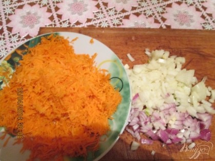 Приготовим зажарку. Порежьте лук, натрите морковь. Лук поджарьте на подсолнечном масле, добавьте морковь.
