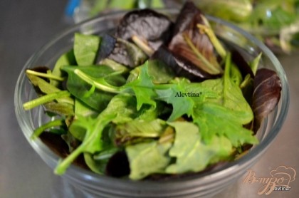 Листья салатные смесь выложим в емкость и смешаем, почистим авокадо и разрежем на дольки.