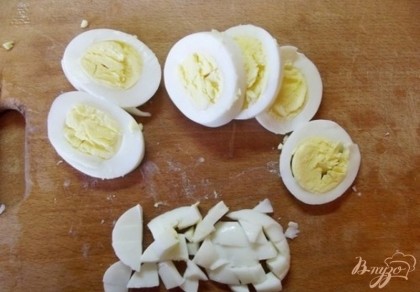На одну порцию салата я предлагаю два яйца. Именно поэтому салат получается очень сытным и полноценным, не требующим при его подаче других блюд. Куриные яйца нужно отварить и остудить. Чтобы яйца лучше чистились сразу из кипятка положите их в холодную воду. Порежьте готовые яйца колечками, а попки измельчите и положите в основной салат.