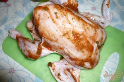 Обмазываем тушку курицы изнутри и снаружи полученной смесью кетчупа с приправами. Включаем духовку, чтобы хорошо разогрелась.