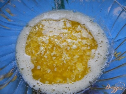 Маргарин растапливаем на огне до жидкого состояния и аккуратно добавляем в сахарно-яичную смесь (вместо маргарина можно использовать сметану пожирнее, её, естественно, нагревать или топить не надо, сразу добавляем в тесто). Также добавляем сок, выжатый из второй половинки лимона. Кожу лимона натираем на мелкой терке - получаем цедру. Натирать следует только желтую часть, если попадет и белая часть, то выпечка может пригарчивать. Полученную лимонную цедру также добавляем в тесто.