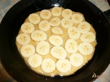 Банан освобождаем от кожуры, затеи нарезаем его тонкими кружочками. алее кружочки банана в один слой раскладываем на тесто в форме, при раскладывании банан чуть-чуть вдавливаем в тесто.