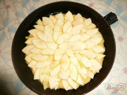 Затем приступаем к яблокам - берем одно крупное или пару мелких, моем, досуха вытираем, разрезаем на четыре части и вырезаем серединку с семечками. Потом нарезаем яблоки тонкими дольками. Если кожа у яблок грубая, то её лучше снять. Нарезанные яблоки выкладываем на тесто. Стараемся выкладывать яблоки поровнее и покрасивее, так так это будет поверхность нашей будущей шарлотки. Сверху посыпаем яблоки оставшейся чайной ложкой сахара. Также слегка посыпаем пирог молотой корицей (по желанию, также можно использовать ванильный сахар).