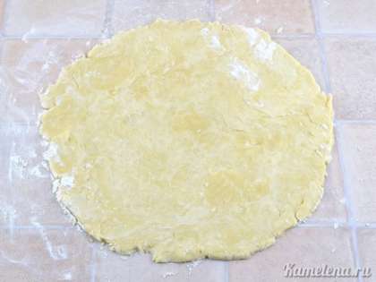 На столе, посыпанном мукой, раскатать тесто в круг диаметром больше на 2-3 см, чем форма для выпечки.