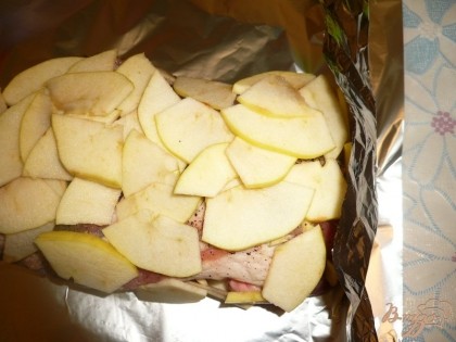 По бокам куска мяса тоже кладем кусочки яблок (кладем сбоку и сразу прижимаем яблоки фольгой).