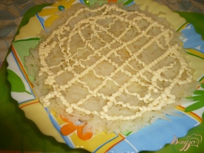 Распределяем натертый картофель по дну тарелки слегка утрамбовывая. Следующий слой - сеточка из майонеза (для того, чтобы нанести сеточку, отрезаем от пакета с майонезом маленький уголок и через него выдавливаем тонкую струйку).