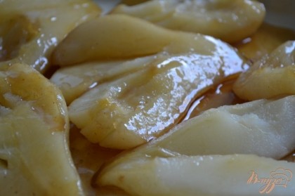 Форму смазать сливочным маслом и выложить половинки груш, нарезав на дольки.