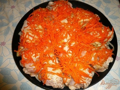 Поверх курицы выкладываем готовую морковь по-корейски так, чтобы она покрывала все кусочки.