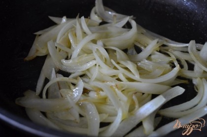 Луковицу порезать на дольки и обжарить до прозрачности на сковороде с оливковым маслом.