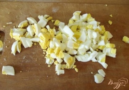 Куриные яйца нужно отварить в крутую (чтобы желток был твердым) и нарезать как в салат.