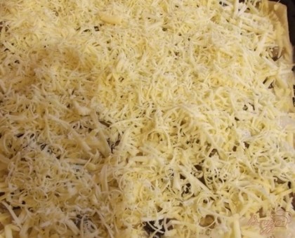 Сыр нужно натереть плотным слоем и отправить пиццу в духовку на 15 мин при 180 градусах. За три минуты до готовности сверху на пиццу можно вбить сырое яйцо (не забудьте присолить).