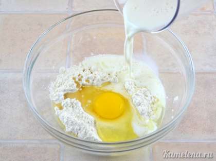 Добавить растительное масло, яйцо. Влить примерно третью часть молока.