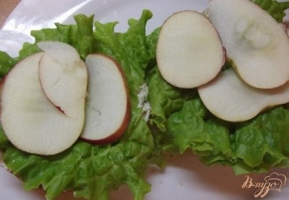 Дальше яблоки. Яблоки должны быть сладкие, не лишком сочные. Лучше брать мягкие, немного полежавшие яблоки, которые не хрустят. Не счищаю с них шкурку вымойте их и нарежьте дольками в треть сантиметра. Выложите поверх салата.