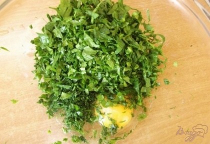 Зелень нужно мелко порубить, можно даже измельчить в блендере. Выложите ее в глубокую миску и положите к ней одно куриное яйцо.