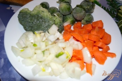 Репчатый лук нарезать. Морковь тоже нарезать. Брюссельская капуста и брокколи у меня мороженные. Я им дала 10 минут полежать и оттаять.