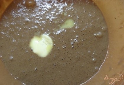 Муку просейте с какао-порошком в соотношении три к одному (три муки один какао-порошок) и порциями подсыпьте смесь в тесто. В чайной ложке погасите щепотку пищевой соды и добавьте в тесто. Шоколад растопите на водяной бане. лейте растопленный, жидкий шоколад в тесто сразу же, как только он растает и миксером на медленной скорости доведите тесто до однородности. Растопите столовую ложку сливочного масло и отправьте ее в след за шоколадом. Также подмешайте чайную ложку растительного масла. благодаря добавлению масла оладьи получаться гладкими и блестящими.
