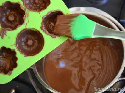 Повторно смазать формочки шоколадом. В кастрюле оставить немного шоколада для донышек.
