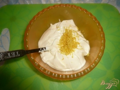 Для приготовления этого десерта нам потребуется качественная, некислая сметана. Вместо сметаны можно использовать мягкий кремовый творожок (можно даже обезжиренный). Выкладываем сметану в небольшую миску. Берем лимон, хорошо его промываем и вытираем досуха. Затем натираем цедру лимона на мелкой терке, натираем аккуратно, так, чтобы не задеть белую часть, а натереть только желтую, иначе наш десерт может горчить. Добавляем лимонную цедру к сметане. Далее добавляем половину чайной ложки сахарной пудры.