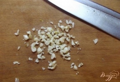 Начните с того, что очистите чеснок и порубите его мелко ножом. Также сразу же поставьте вариться рис. Его нужно снять с огня когда он будет еще немного сыроват.