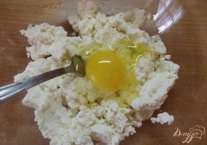 Вбейте к творогу одно куриное яйцо и разомните их вместе до однородности.