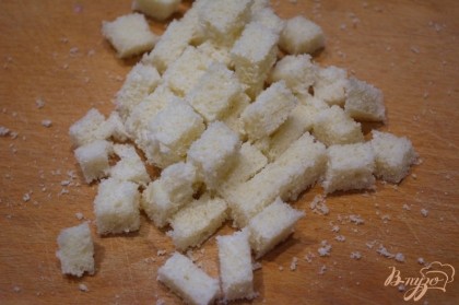 Батон белого хлеба нарезать на кубики.