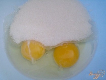 Взбиваем яйца с сахаром. Лучше это сделать миксером, чтобы масса посветлела и немного увеличилась в объеме. Вводим сметану или кефир. Вливаем уксус столовый 9%. Размешиваем.