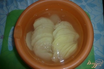 Картофель промываем, чистим, еще раз споласкиваем чистой водой и нарезаем тоненькими ломтиками (кружочками). Нарезанный картофель складываем в подходящую миску и заливаем холодной водой, пусть постоит так хотя бы полчасика.