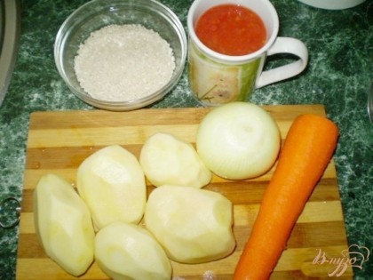 Подготовим продукты: почистить лук, морковь, картофель. Рис замочить в холодной воде, потом промыть до прозрачной воды. Можно томатный сок заменить пастой, разведенной с водой. Налейте в кастрюлю воду и доведите до кипения. Посолите. Картофель нарезаем кубиками или соломкой и бросаем вместе с рисом в кипящую воду и варим до готовности, но не более 30 минут.
