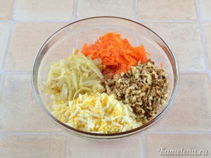 В салатник положить морковь, лук, грецкие орехи, яйца. Посолить, поперчить, полить растительным маслом, хорошо перемешать.